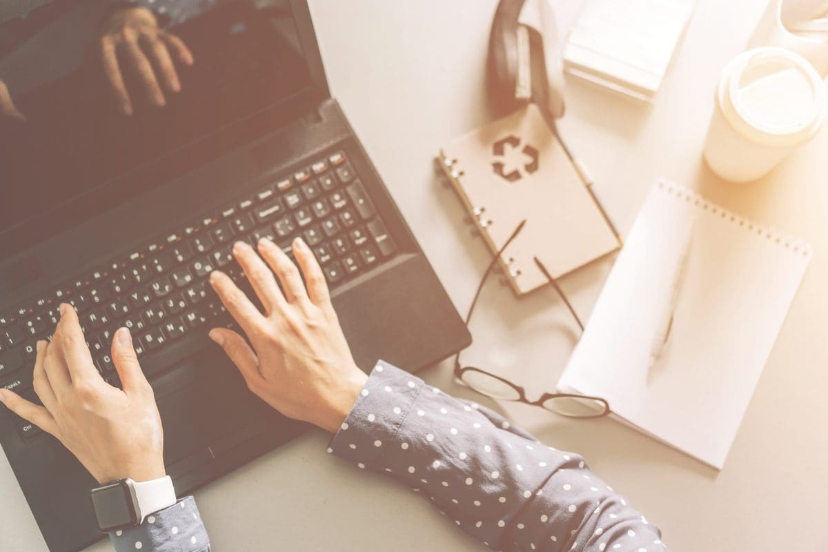 Hands typing on a laptop